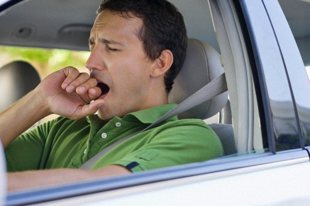 Mid adult man yawning while driving a car --- Image by © Eric Audras/Onoky/Corbis